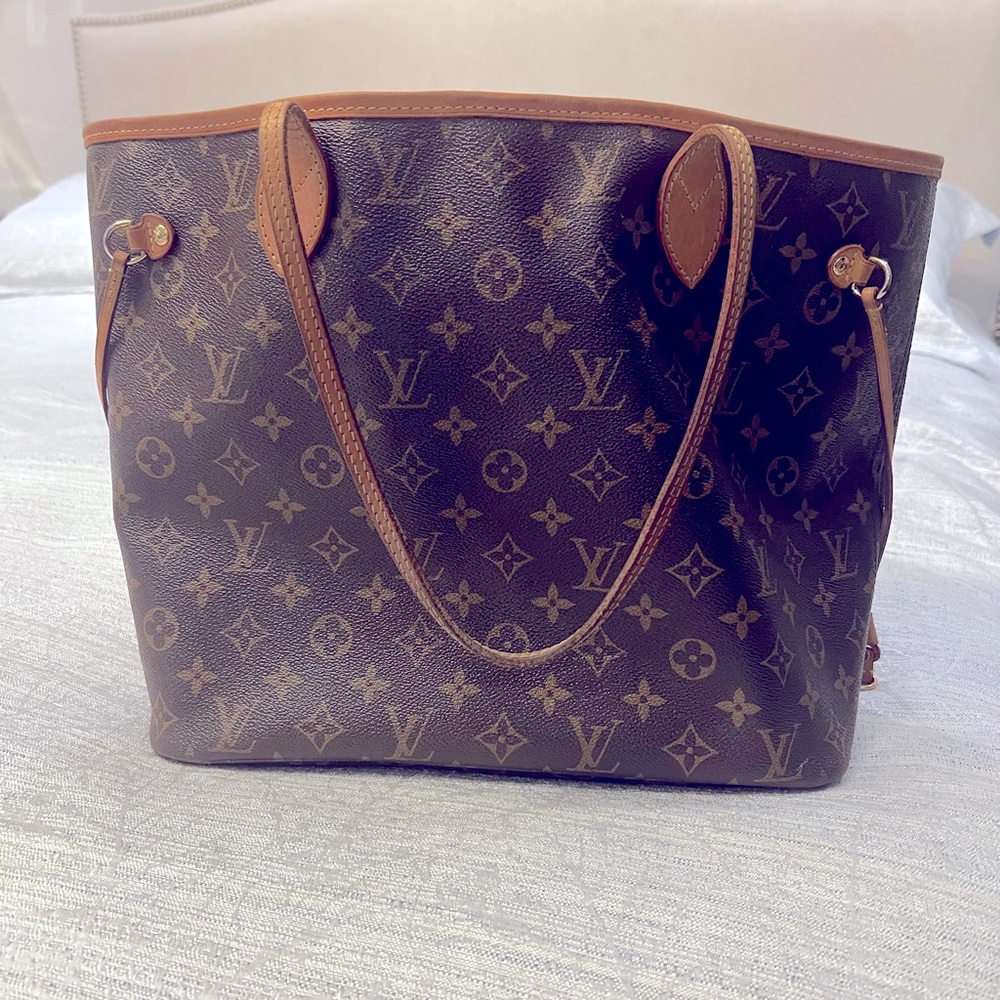 LV The Neverfull MM tote unites timeless design with heritage details.